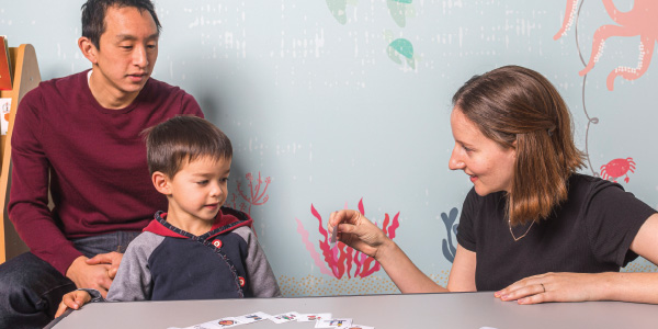 Child interacting with practitioner while parent looks on