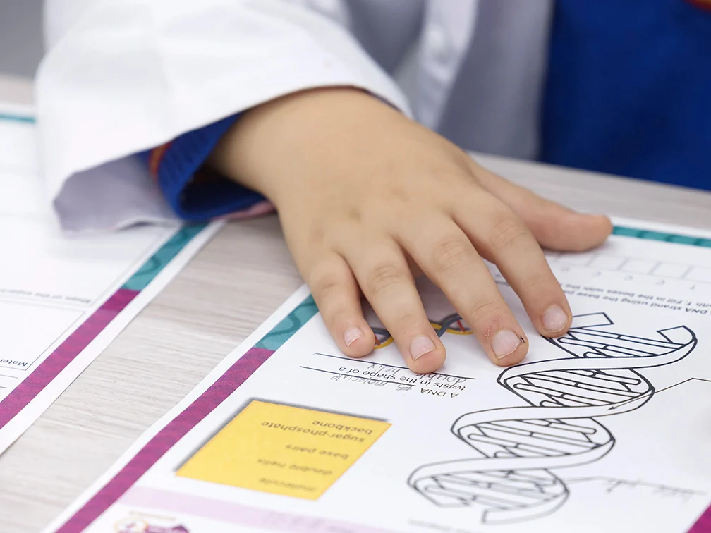 a child writing on a science worksheet