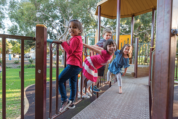 A group of preschoolers play on a playground